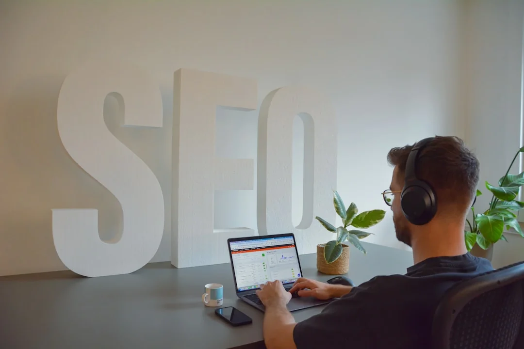 A modern workspace showing hands analyzing marketing data on a laptop and paper documents.
